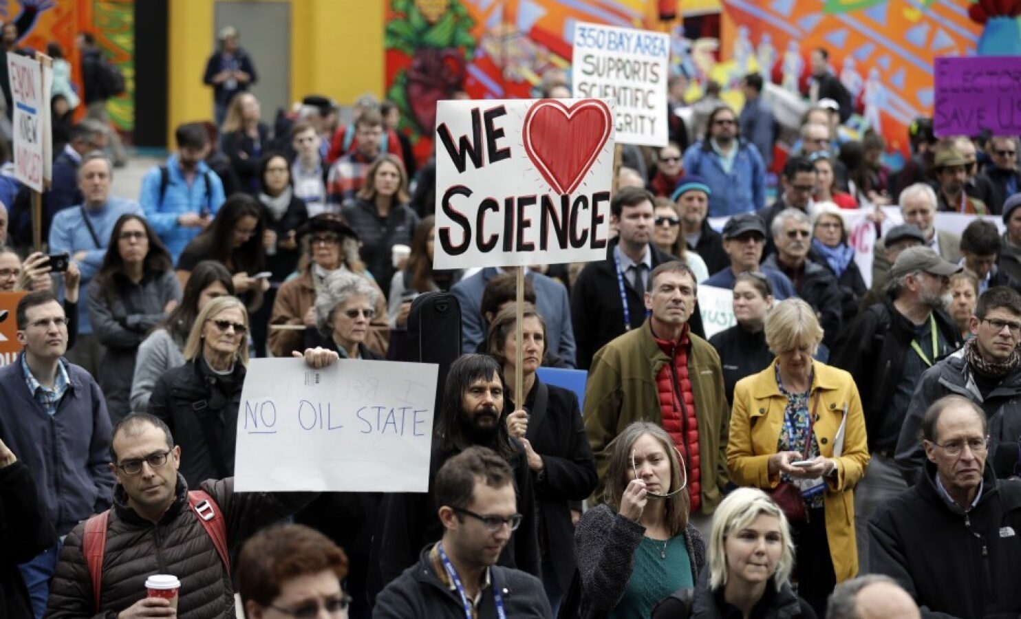People hold signs as they listen to a group of scientists speak during a rally in conjunction with the American Geophysical Union's fall meeting in San Francisco. (AP Photo/Marcio Jose Sanchez)