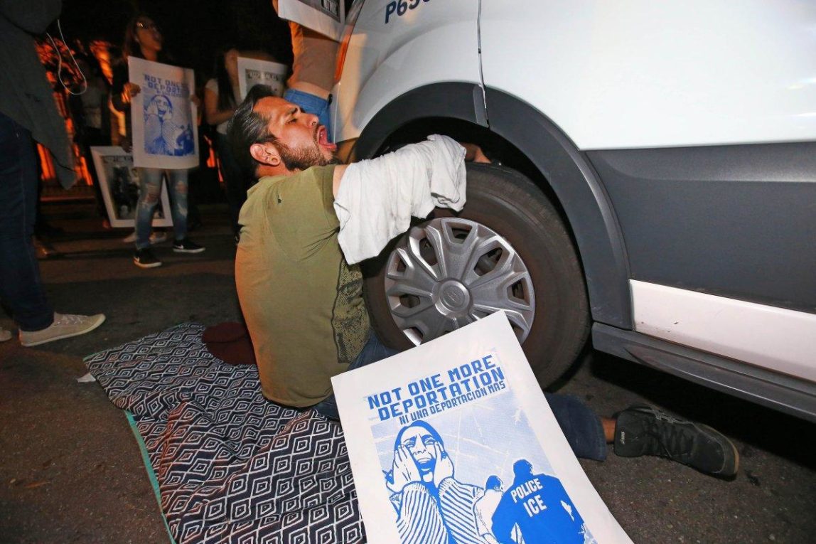 A protester locked himself to the van carrying Garcia de Rayos. (ROB SCHUMACHER/THE ARIZONA REPUBLIC VIA AP)