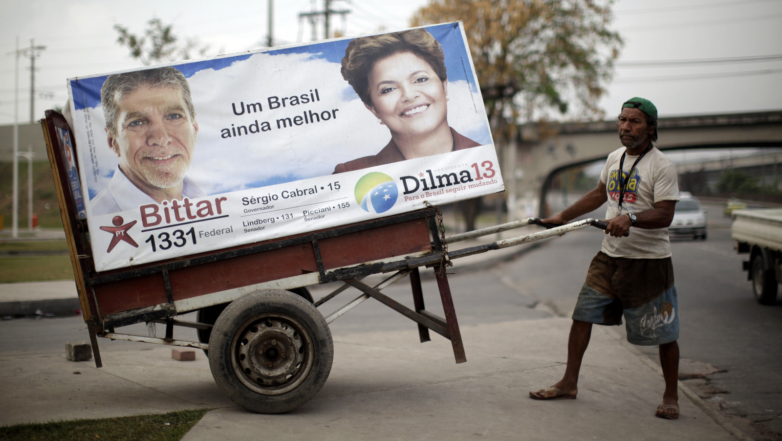 A man pulls a cart with an electoral poster of Workers Party presidential candidate Dilma Rousseff, right, at Manguinhos slum in Rio de Janeiro, Brazil, Wednesday, Sept. 29, 2010. (AP/Felipe Dana)