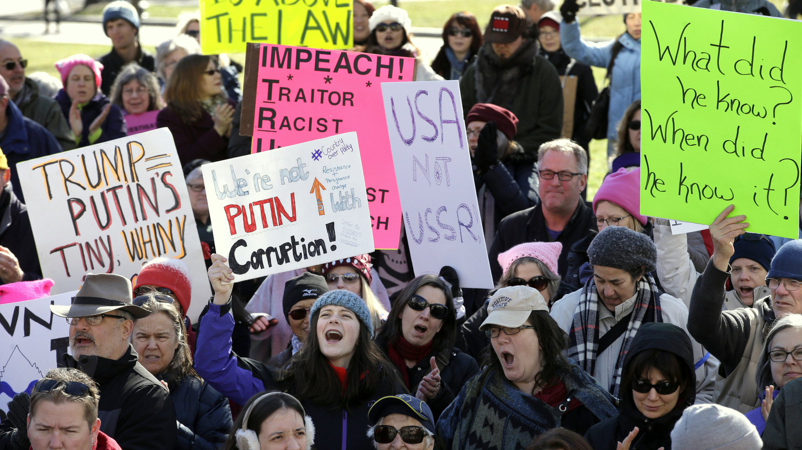 Protesters hold placards and chant slogans during a demonstration called "Emergency Rally to Stand for Democracy," Sunday, Feb. 26, 2017, in Boston. Demonstrators called for an investigation into what they describe as the possible involvement of Russian officials in the campaign of then presidential candidate Donald Trump in the Nov. 2016 electio