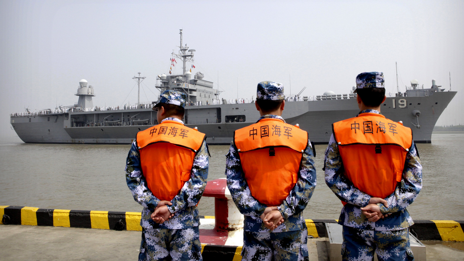 Soldiers from the Chinese People's Liberation Army (PLA) Navy watch as the USS Blue Ridge arrives at a port in Shanghai, Friday, May 6, 2016. (AP Photo)
