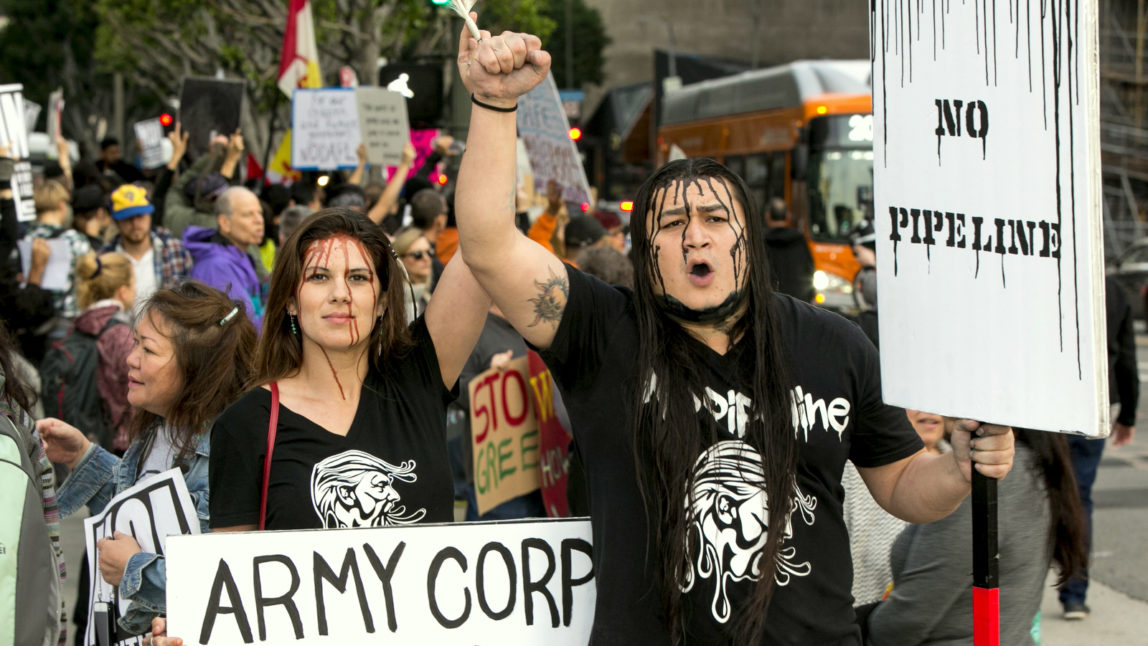 Toyah Browneyes, left, and Lance Browneyes join opponents of the Dakota Access pipeline outside the Army Corps of Engineers offices in Los Angeles Wednesday, Feb. 8, 2017, in response to the Army Corps of Engineers saying it will clear the way for completion of the disputed $3.8 billion project to carry North Dakota oil to Illinois. (AP/Damian Dovarganes)