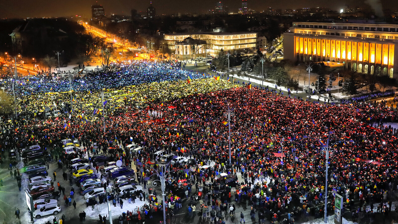 People light the flashes of their mobile phones in the colors of Romania's flag during an anti-government protest in Bucharest, Romania, Sunday, Feb. 12, 2017. Protesters braved freezing temperatures gathering outside the government headquarters for the 13th consecutive day to demand the government's resignation after it passed a decree that would have diluted the anti-corruption fight that has targeted top officials.(AP/Vadim Ghirda)