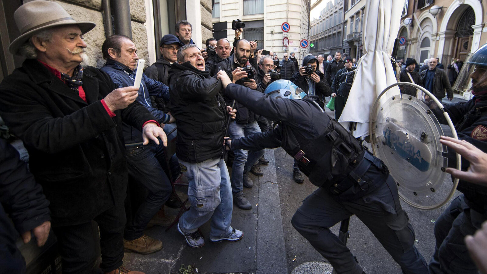 Riot police clash with taxi drivers and street sellers during a demonstration, in Rome, Tuesday, February 21, 2017. A weeklong strike by taxi drivers that has crippled transport in Rome, Milan and Turin is heating up, with cabbies marching through the eternal city to protest legislation they say will favor Uber and other car-hire services. (Massimo Percossi/ANSA via AP)