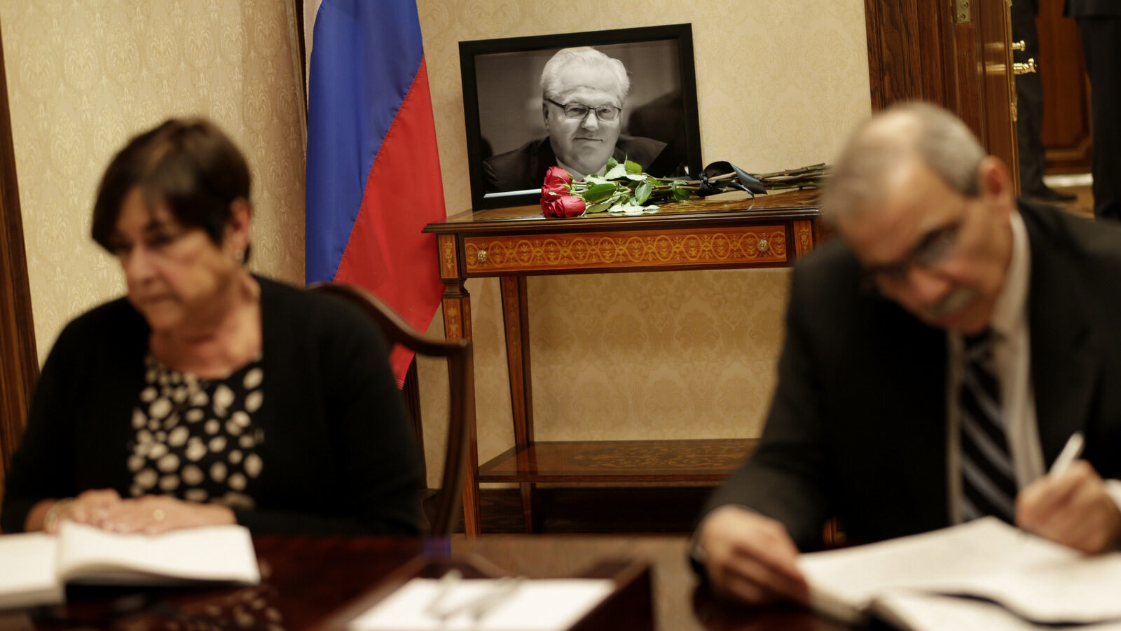 A picture of Vitaly Churkin, Russia's ambassador to the United Nations, is displayed while people sign condolences books at the Russian Mission to the U.N. in New York, Tuesday, Feb. 21, 2017. The city medical examiner was expected to perform an autopsy Tuesday on Russia's ambassador to the U.N., who died a day earlier after falling ill at his office at Russia's U.N. mission. (AP/Seth Wenig)