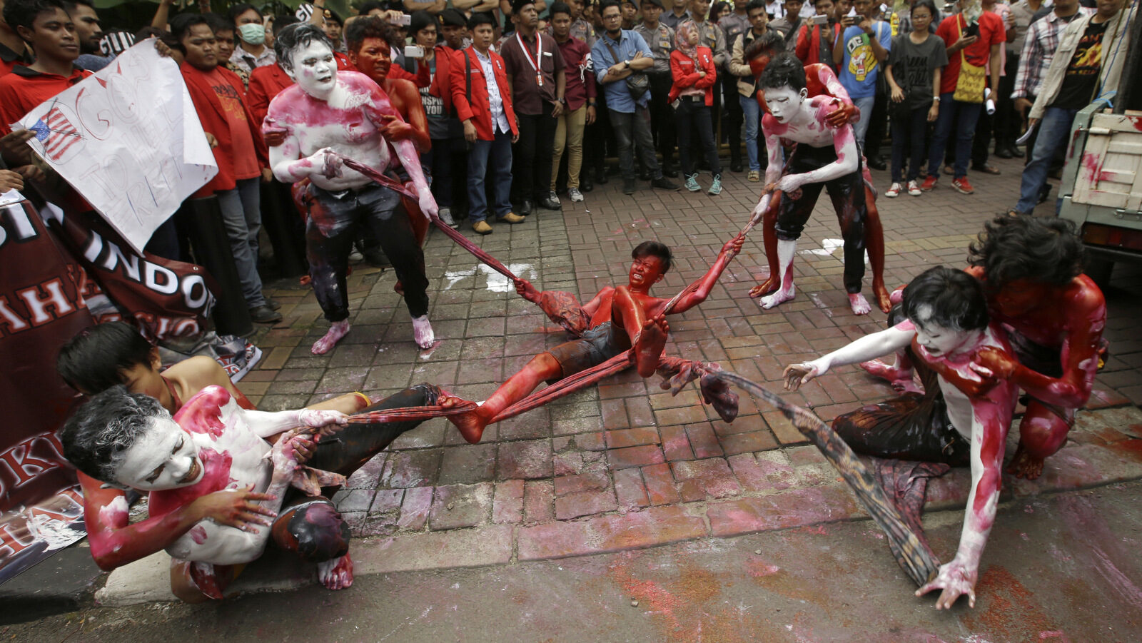Students with painted bodies perform a skit during a demonstration against the U.S. mining giant Freeport-McMoRan Copper & Gold Inc. in Jakarta, Indonesia, Friday, Feb. 24, 2017. Dozens of students staged the protest demanding the New Orleans-based mining company close its mine in Papua province saying that it siphons of the region's wealth and gives it little in return. (AP/Achmad Ibrahim)
