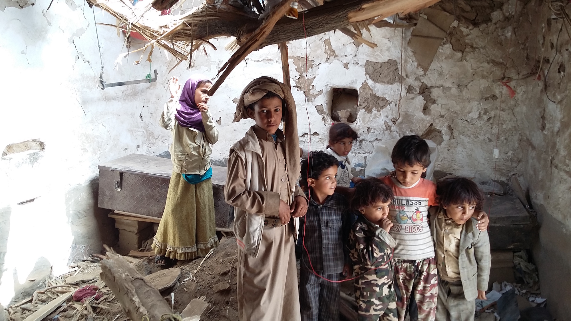 Relatives of people killed in the raid gather in one of the decimated houses. (Photo: Nasser al Sane)