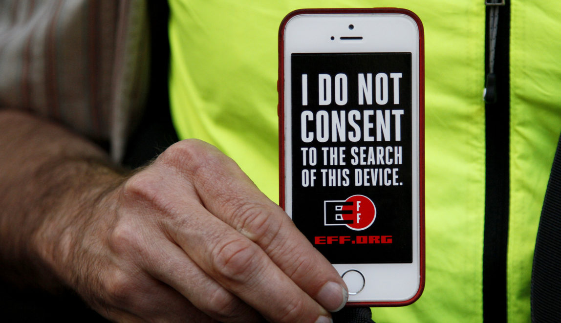 A man holds up his iPhone during a rally in support of data privacy outside the Apple store in San Francisco. (AP/Eric Risberg)