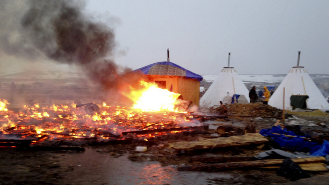 Dakota Access pipeline opponents burn structures in their main protest camp in southern North Dakota near Cannon Ball, N.D., on Wednesday, Feb. 22, 2017, as authorities prepare to shut down the camp in advance of spring flooding season. (AP Photo/James MacPherson)