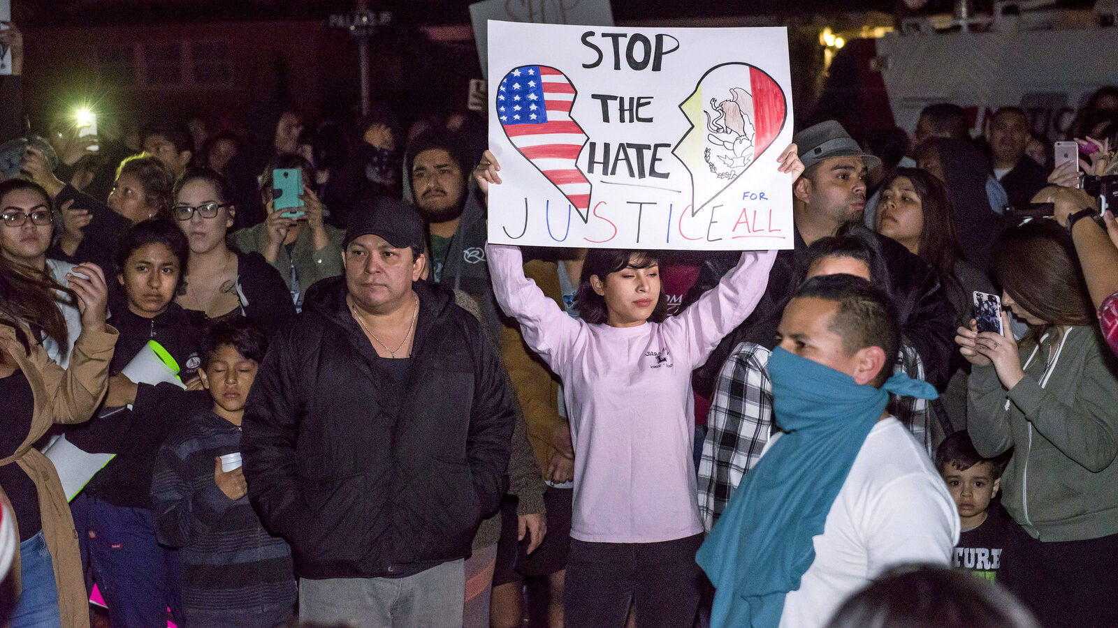 Protesters hold signs in front of an LAPD officer's home in Anaheim, Calif., Wednesday, Feb. 22, 2017. (Joshua Sudock/The Orange County Register via AP)