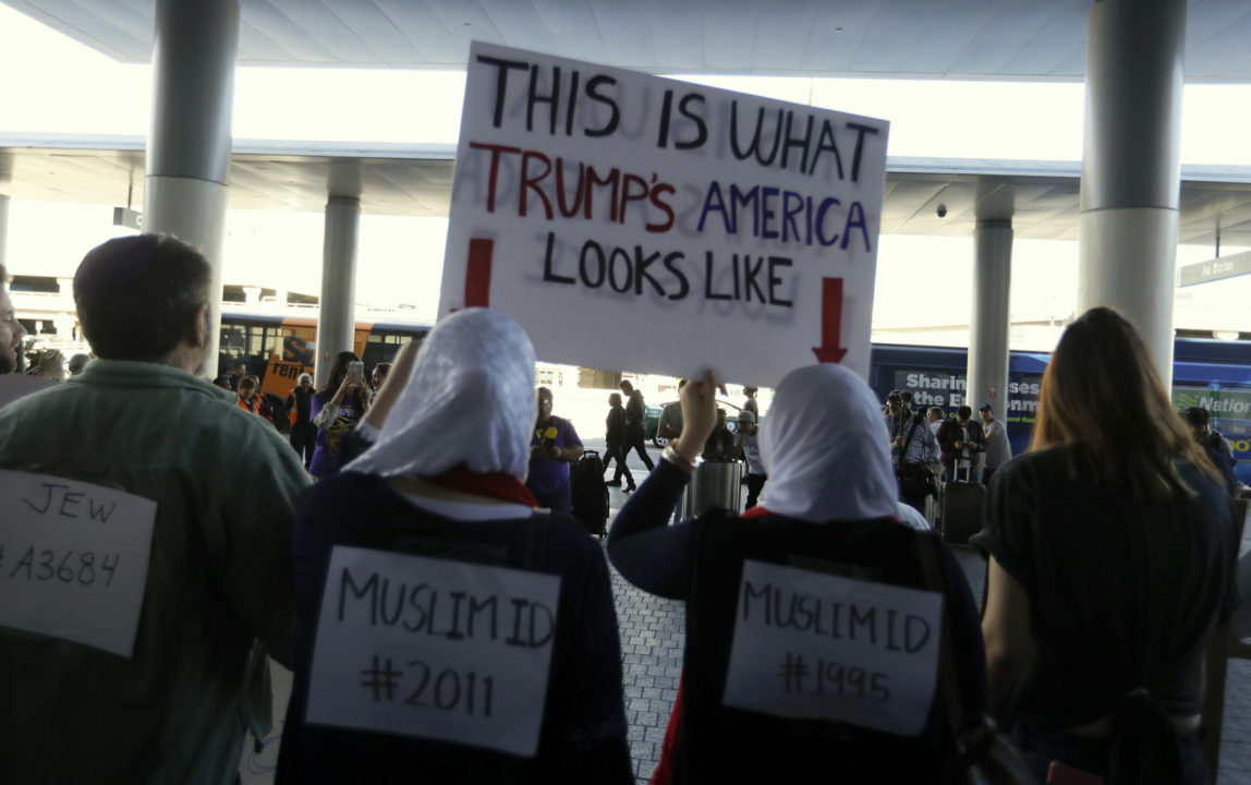 Demonstrators chant outside Tom Bradley International Terminal during a protest by airport service workers from United Service Workers West union Monday, Jan. 30, 2017, at Los Angeles International Airport. The vigil in support of travelers affected by Trump's Muslim ban. (AP/Chris Carlson)