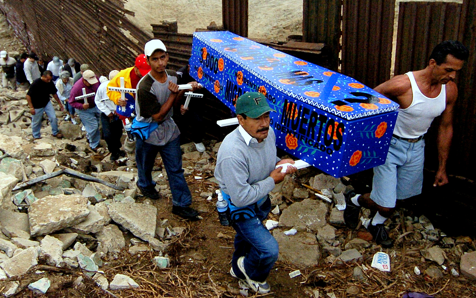 Marchers carry a casket along a section of the U.S.-Mexico border fence in Tijuana, Mexico Friday, Oct. 1, 2004, to mark the 10th anniversary of the U.S. border enforcement program Operation Gatekeeper. (AP/Denis Poroy)