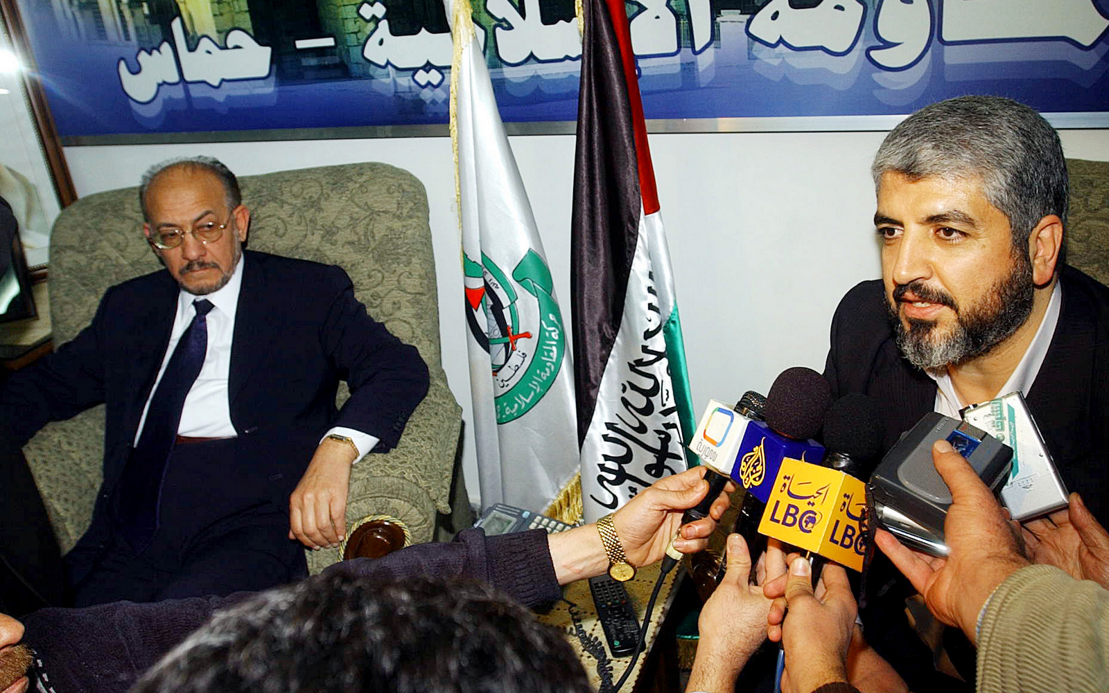Highly ranking Muslim Brotherhood official Abdul-Majeed Zneibat, left, listens as Hamas leader Khaled Mashaal, right, talks to reporters in Damascus, Tuesday Jan, 31, 2006 . (AP/Bassm Tellawi).