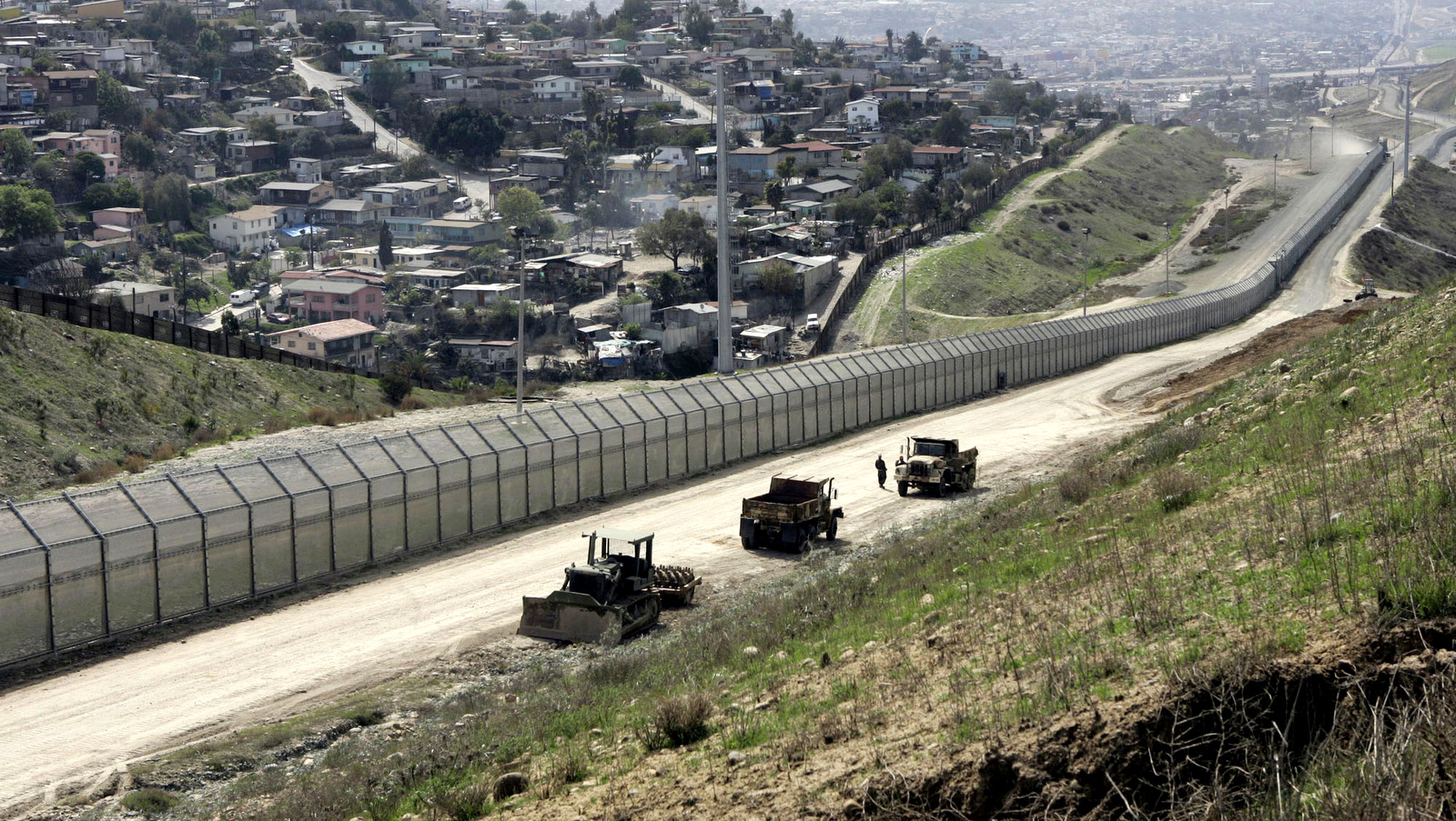 The U.S.-Mexico border fence stretches 14 miles inland separating San Diego and Tijuana, Mexico, in this March 27, 2006, file photo. The homes at left are in Tijuana. This section of became the western-most end of the fence when an additional 700 miles of non-contiguous fencing, was erected between California and Texas as a part of the Secure Fence Act. (AP/Lenny Ignelzi)