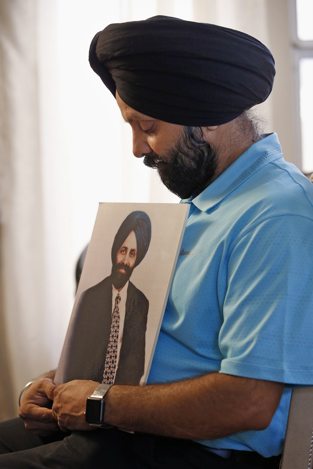 Rana Singh Sodhi holds a photograph of his murdered brother, Balbir Singh Sodh. Days after the Sept. 11, 2001 terrorist attacks, Balbir was shot dead while placing flowers on a memorial at his gas station in Mesa. Prosecutors said the gunman mistook Sodhi, an Indian Sikh immigrant, for an Arab Muslim. (AP/Ross D. Franklin)