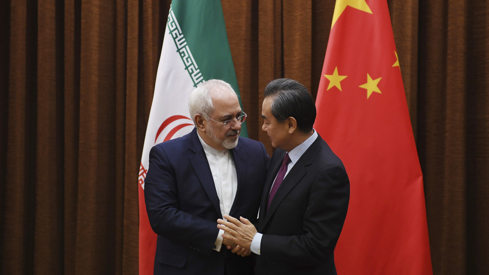 Iranian Foreign Minister Mohammad Javad Zarif, left, is greeted by Chinese Foreign Minister Wang Yi before a meeting in Beijing Monday, Dec. 5, 2016. (Greg Baker/AP)