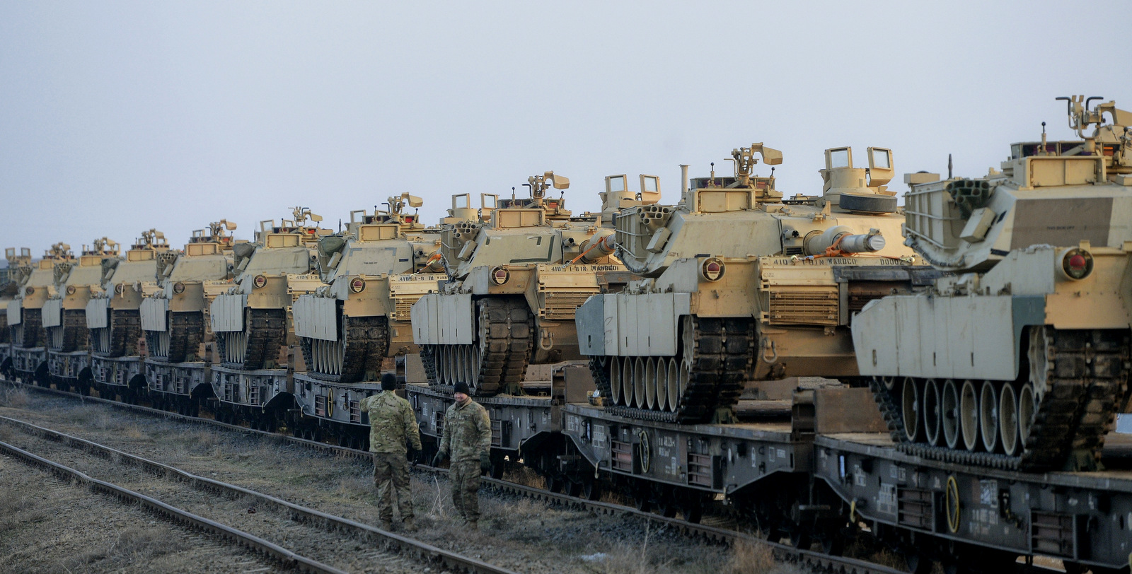 Servicemen of the "Fighting Eagles" 1st Battalion, 8th Infantry Regiment, walk by tanks that arrived via train to the US base in Mihail Kogalniceanu, eastern Romania, Tuesday, Feb. 14, 2017. (AP/Andreea Alexandru)