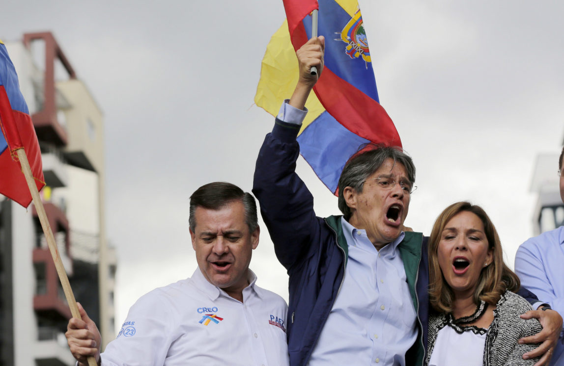 Guillermo Lasso, center, cheers, accompanied by his wife and his running mate outside the Electoral National Council where supporters were waiting for election results, in Quito, Ecuador, Tuesday, Feb. 21, 2017. (AP/Dolores Ochoa)