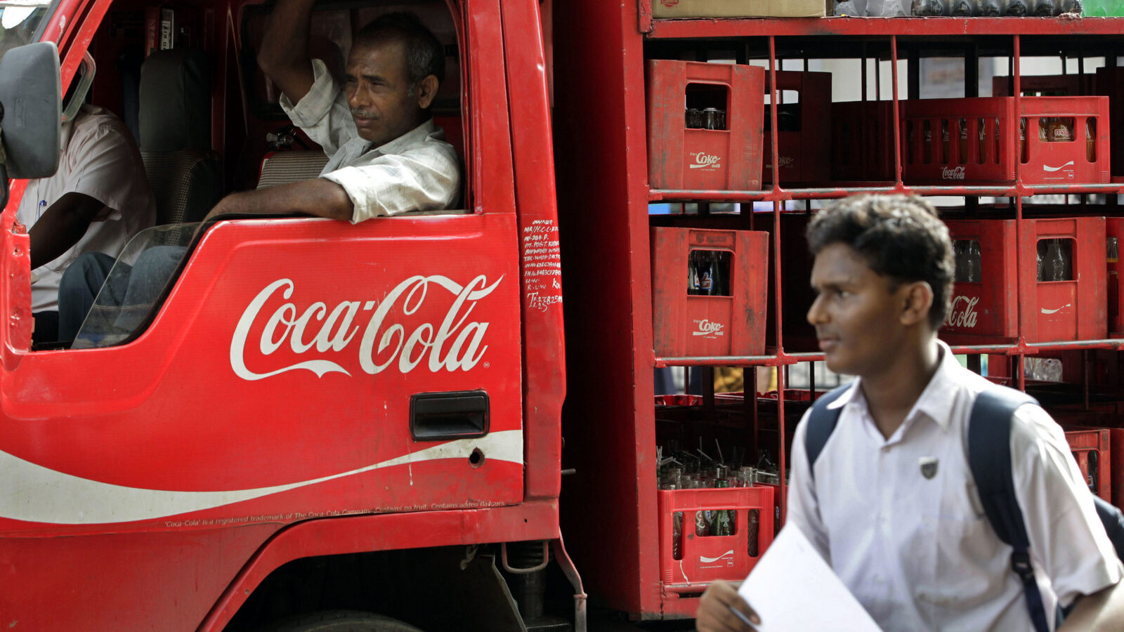 A man walks past a truck that distributes Coca Cola in Mumbai, India. (AP/Rajanish Kakade)