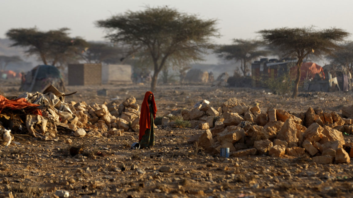 A Somali woman walks through a camp of people displaced from their homes elsewhere in the country by the drought, shortly after dawn in Qardho, Somalia Thursday, March 9, 2017. (AP/Ben Curtis)