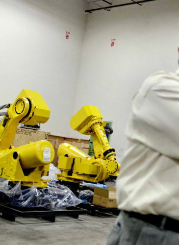 Rosser Pryor, Co-owner and President of Factory Automation Systems, stands near new high-performance industrial robots at the company's Atlanta facility. (AP/David Goldman)