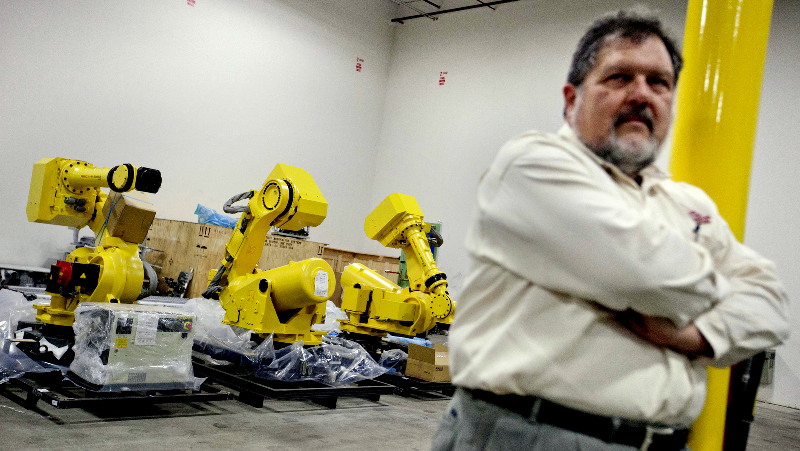 Rosser Pryor, Co-owner and President of Factory Automation Systems, stands near new high-performance industrial robots at the company's Atlanta facility. (AP/David Goldman)