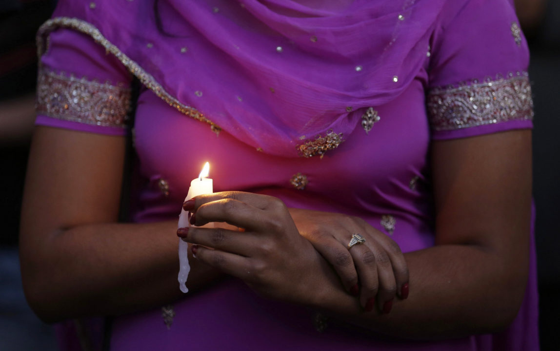 A woman takes part in a candle light vigil for the victims of the Sikh Temple of Wisconsin shooting, Aug. 5, 2012, in Milwaukee. An unidentified gunman killed six people at the suburban Milwaukee temple, confusing them for Muslim worshipers. (AP/Jeffrey Phelps)
