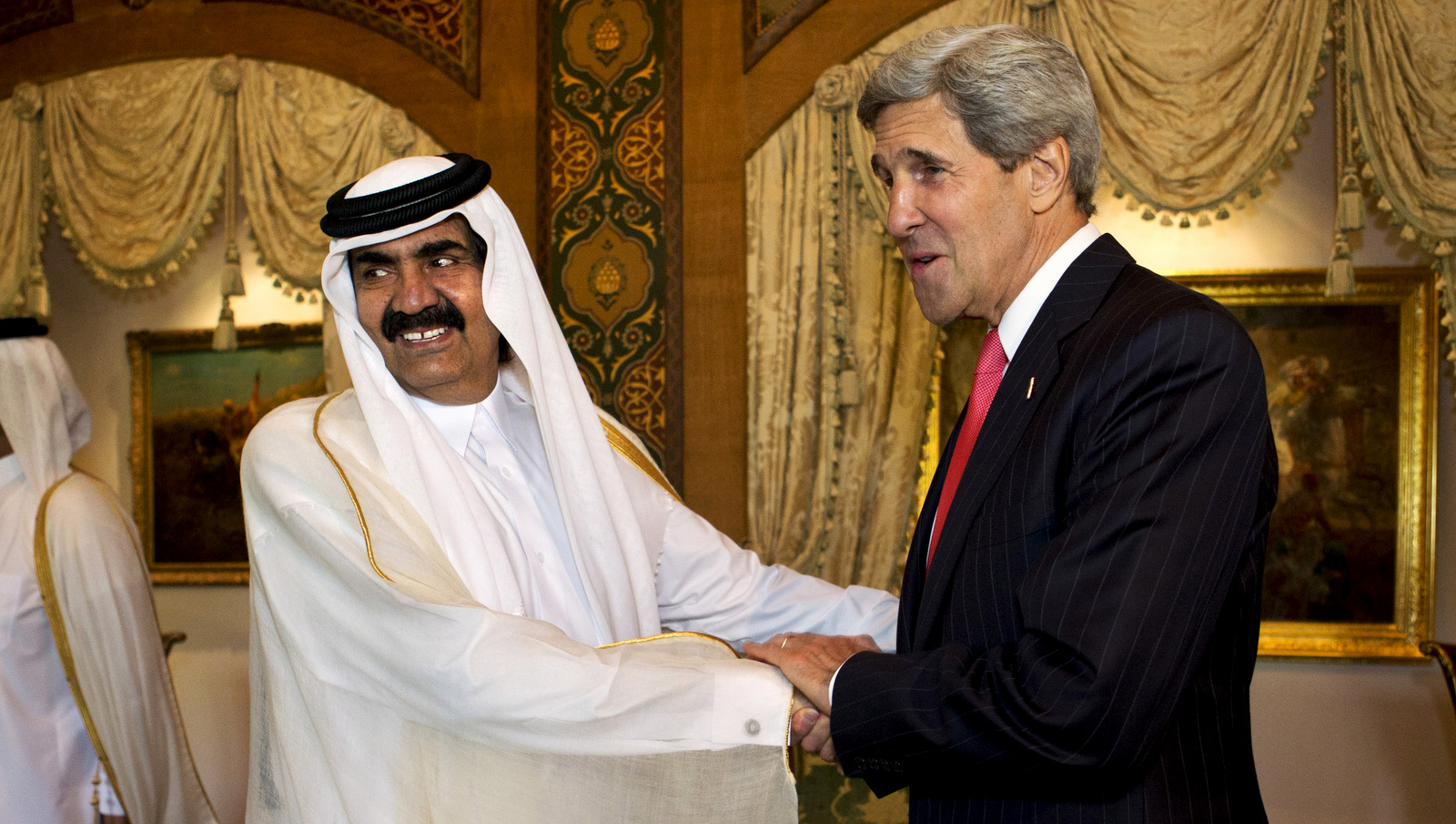 U.S. Secretary of State John Kerry, right, is greeted by Qatari Emir Hamad bin Khalifa Al Thani at Wajbah Palace in Doha, Qatar, on Sunday, June 23, 2013. In Qatar Kerry spent time discussing Syria and Afghanistan. (AP/Jacquelyn Martin)