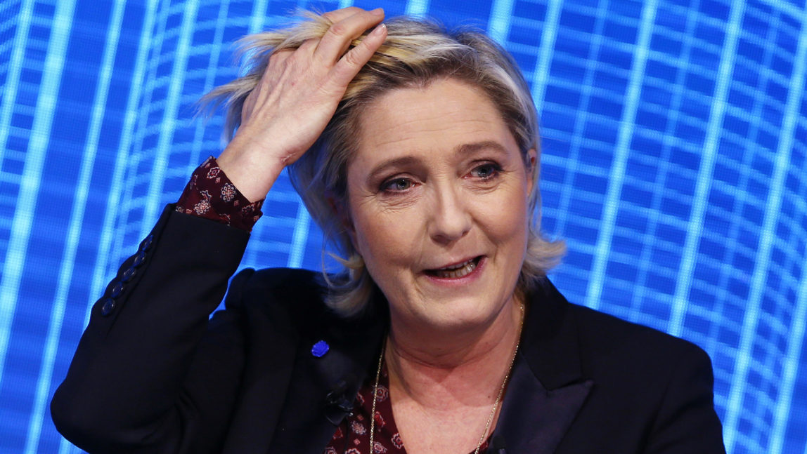 Marine Le Pen, the French far-right presidential candidate adjuts her hair as she attends a debate in Paris. The European Parliament has voted Thursday March 2, 2017 to lift Le Pen's immunity from prosecution. (AP/Francois Mori)