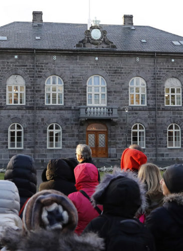 People looking at the Icelandic parliament the Althing in Reykjavik. ﻿﻿﻿Iceland will be the first country in the world to make employers prove they offer equal pay regardless of gender, ethnicity, sexuality or nationality, the Nordic nation's government said on International Women's Day. (AP/Frank Augstein)
