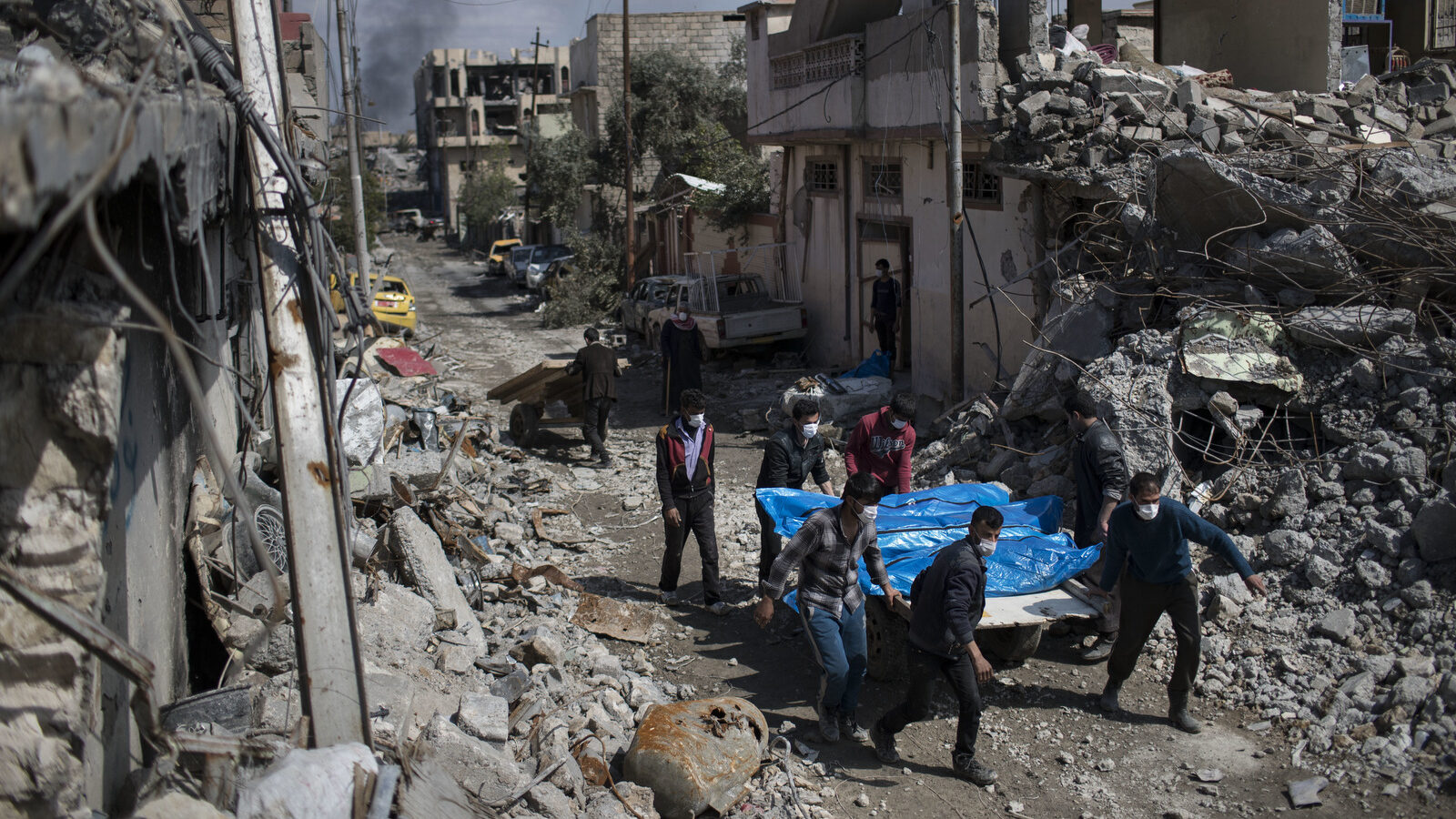 Residents carry the body of several people killed in Mosul, Iraq, Friday, March 24, 2017. Residents of the Iraqi city's neighborhood known as Mosul Jidideh at the scene say that scores of residents are believed to have been killed by airstrikes that hit a cluster of homes in the area. (AP/Felipe Dana)