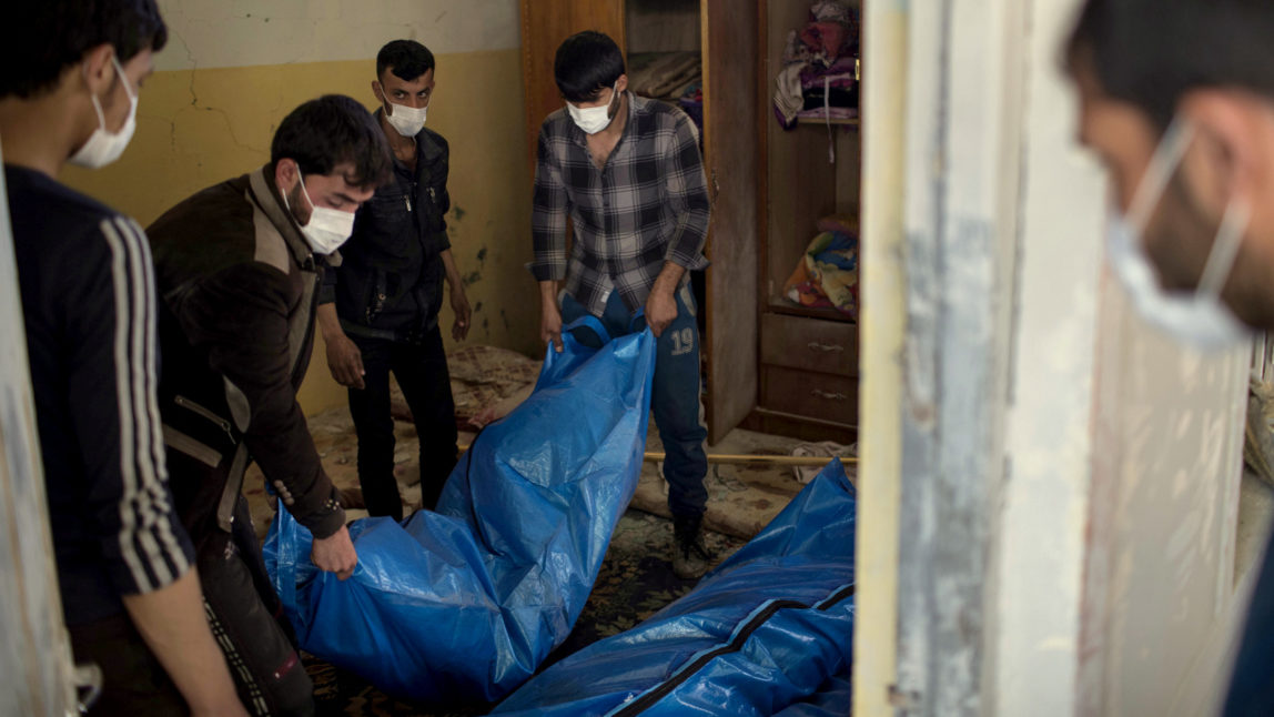 Residents carry the body of a person killed during fights between Iraq security forces and Islamic State on the western side of Mosul, Iraq, Friday, March 24, 2017. Residents of the Iraqi city's neighborhood known as Mosul Jidideh at the scene say that scores of residents are believed to have been killed by airstrikes that hit a cluster of homes in the area earlier this month (AP Photo/Felipe Dana)