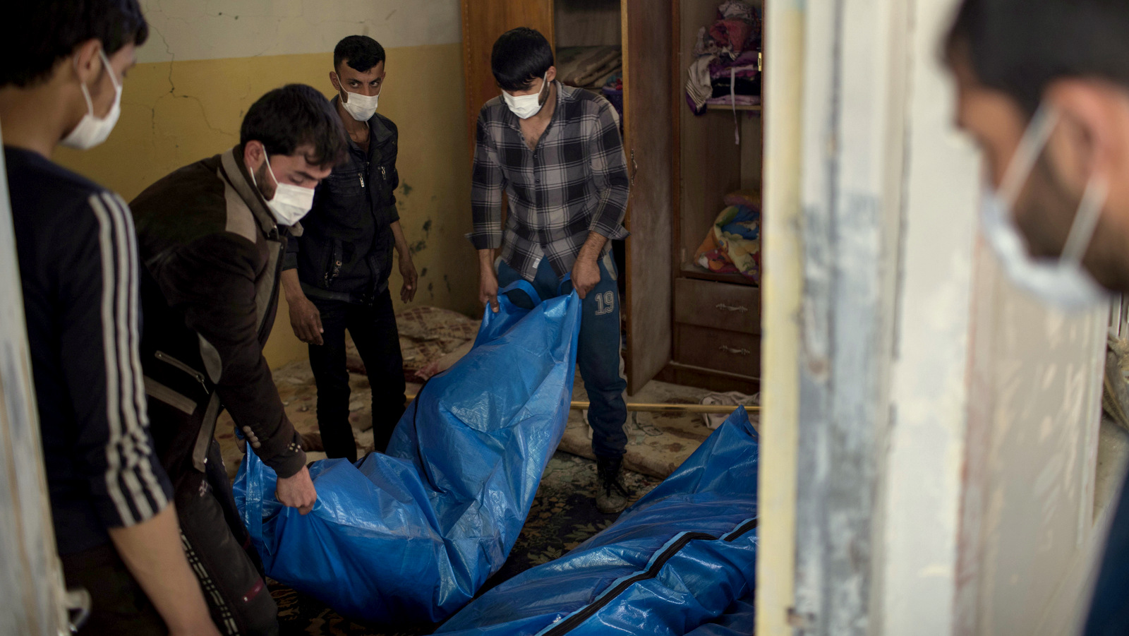 Residents carry the body of a person killed during fights between Iraq security forces and Islamic State on the western side of Mosul, Iraq, Friday, March 24, 2017. Residents of the Iraqi city's neighborhood known as Mosul Jidideh at the scene say that scores of residents are believed to have been killed by airstrikes that hit a cluster of homes in the area earlier this month (AP Photo/Felipe Dana)