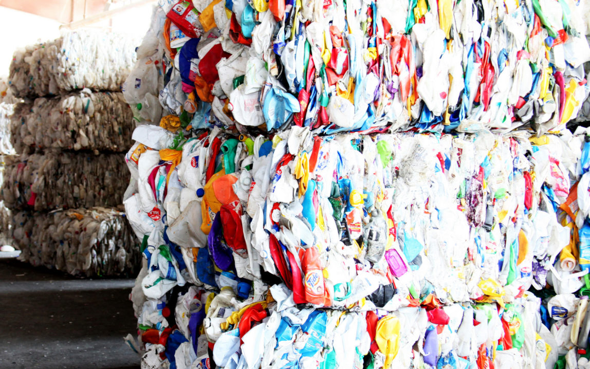 Baled plastic bottles waiting to be recycled at a UK recycling facility.
