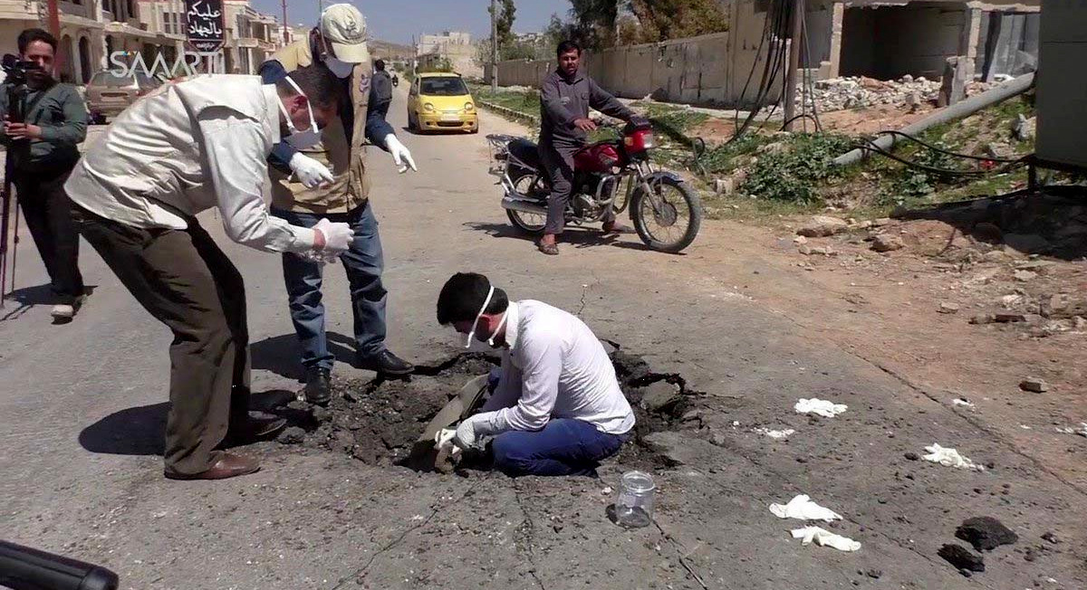 Photograph of men in Khan Sheikdoun, Syria, allegedly inside a crater where a sarin-gas bomb landed on April 4, 2017.