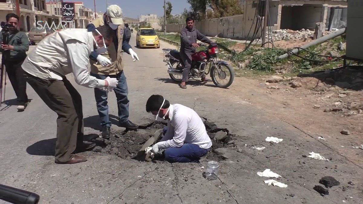 Photograph of men in Khan Sheikhoun in Syria, allegedly inside a crater where a sarin-gas bomb landed.