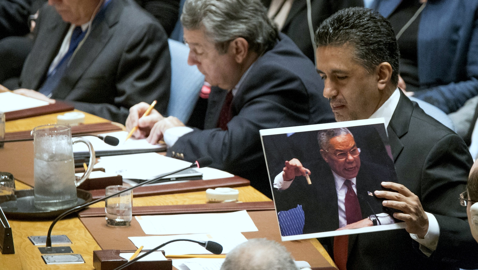 Bolivian Ambassador to the United Nations Sacha Sergio Llorenti Soliz holds a photo of former U.S. Secretary of State Colin Powell holding up a vial that he described as one that could contain anthrax, during a Security Council meeting on the situation in Syria, Friday, April 7, 2017 at United Nations headquarters. (AP Photo/Mary Altaffer)