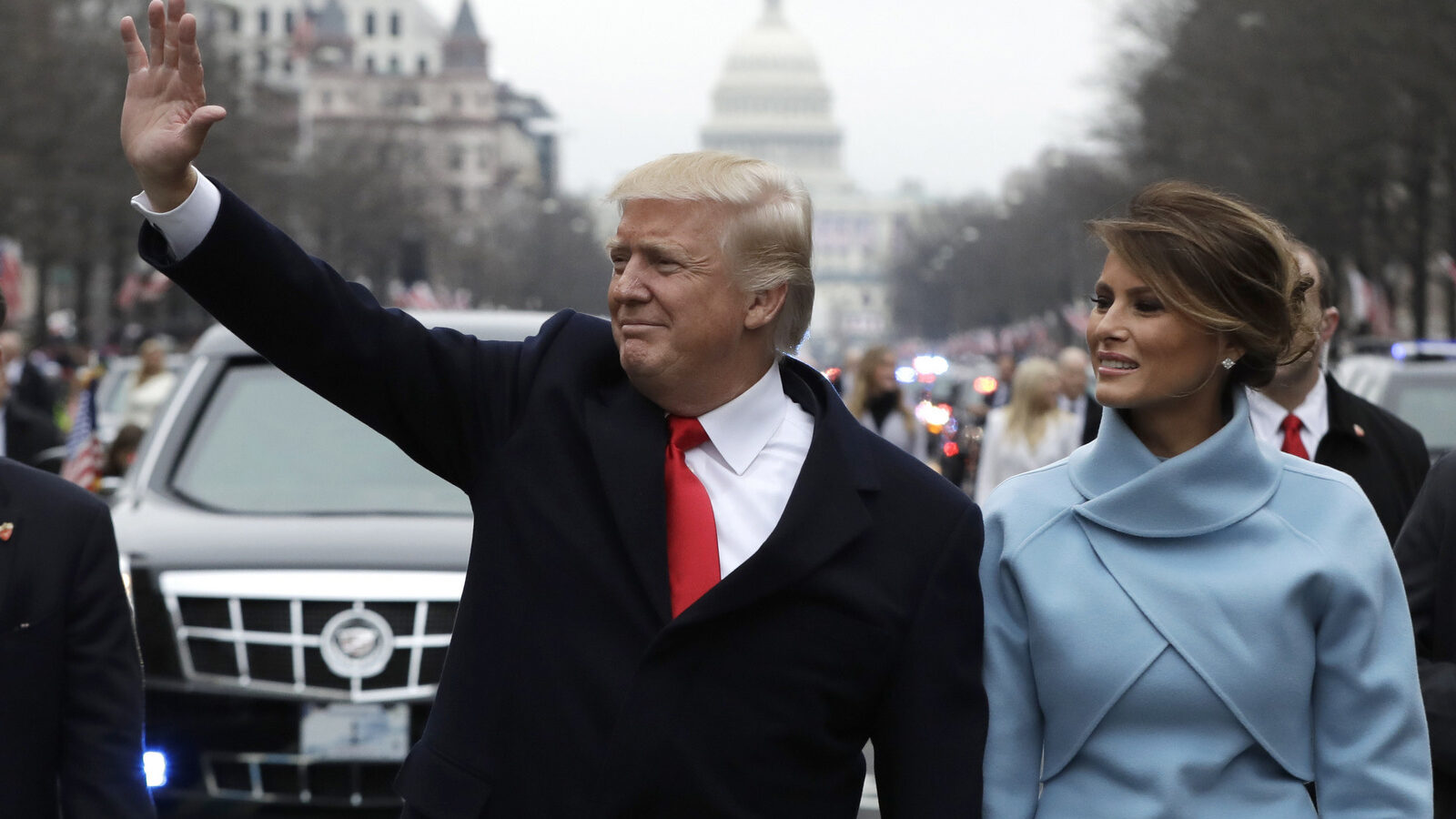 Donald Trump waves as he walks with first lady Melania Trump during the inauguration parade on Pennsylvania Avenue in Washington. Trump raised $107 million for his inaugural festivities. (AP/Evan Vucci)