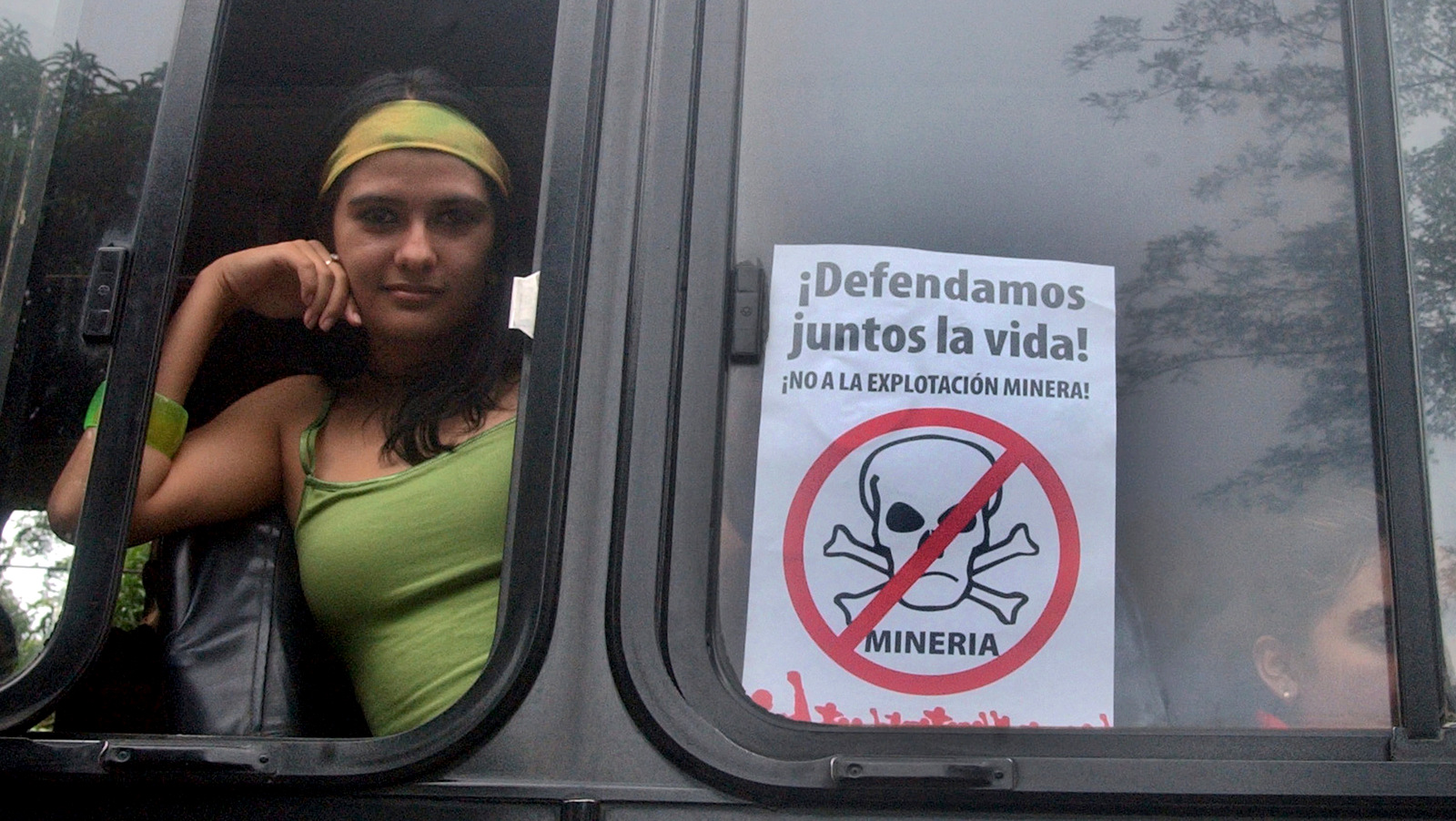 A woman in a bus observes a march protesting the cost of living in Aguilares, El Salvador, some 13 miles north of San Salvador, the sign reads "Together lets defend life! No to mining exploitation." (AP/Edgar Romero)