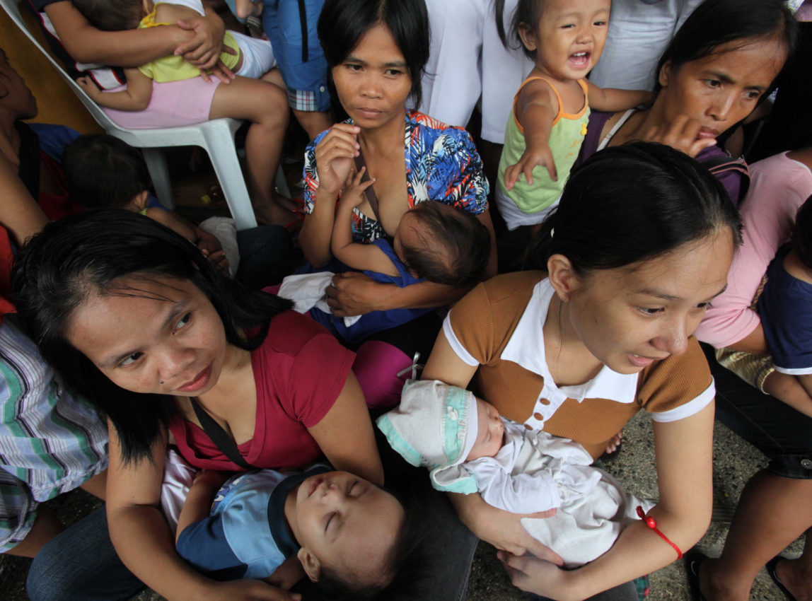 Mothers cuddle their babies as they undergo free medical checkups under the United Nations Population Fund at Cainta Town Hall at Cainta township, Rizal province east of Manila, Philippines.. (AP/Bullit Marquez)