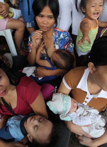 Mothers cuddle their babies as they undergo free medical checkups under the United Nations Population Fund at Cainta Town Hall at Cainta township, Rizal province east of Manila, Philippines.. (AP/Bullit Marquez)