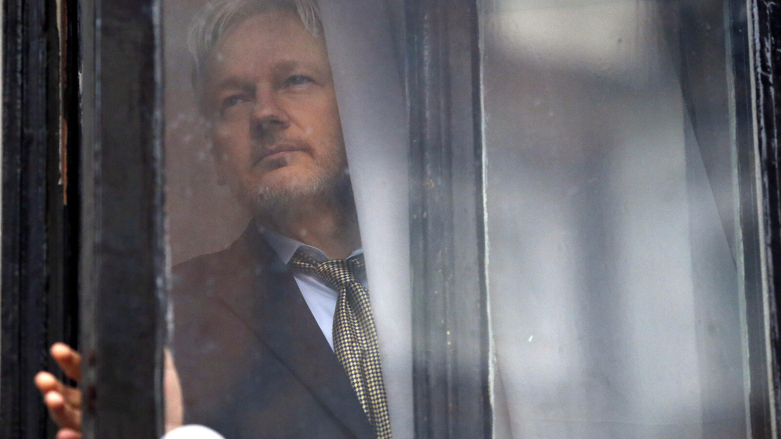 WikiLeaks founder Julian Assange walks onto the balcony of the Ecuadorean Embassy to addresses waiting supporters and media in London, Friday, Feb. 5, 2016. (AP/Frank Augstein)