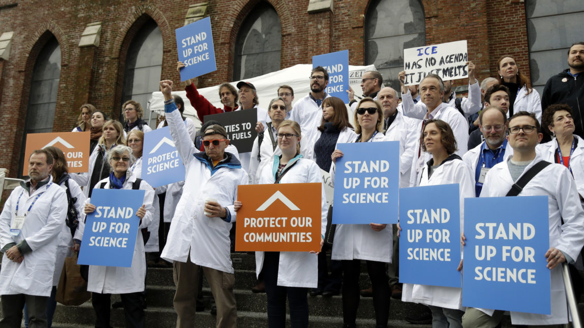 Scientists hold signs during a rally in conjunction with the American Geophysical Union's fall meeting Tuesday, Dec. 13, 2016, in San Francisco. (AP/Marcio Jose Sanchez)
