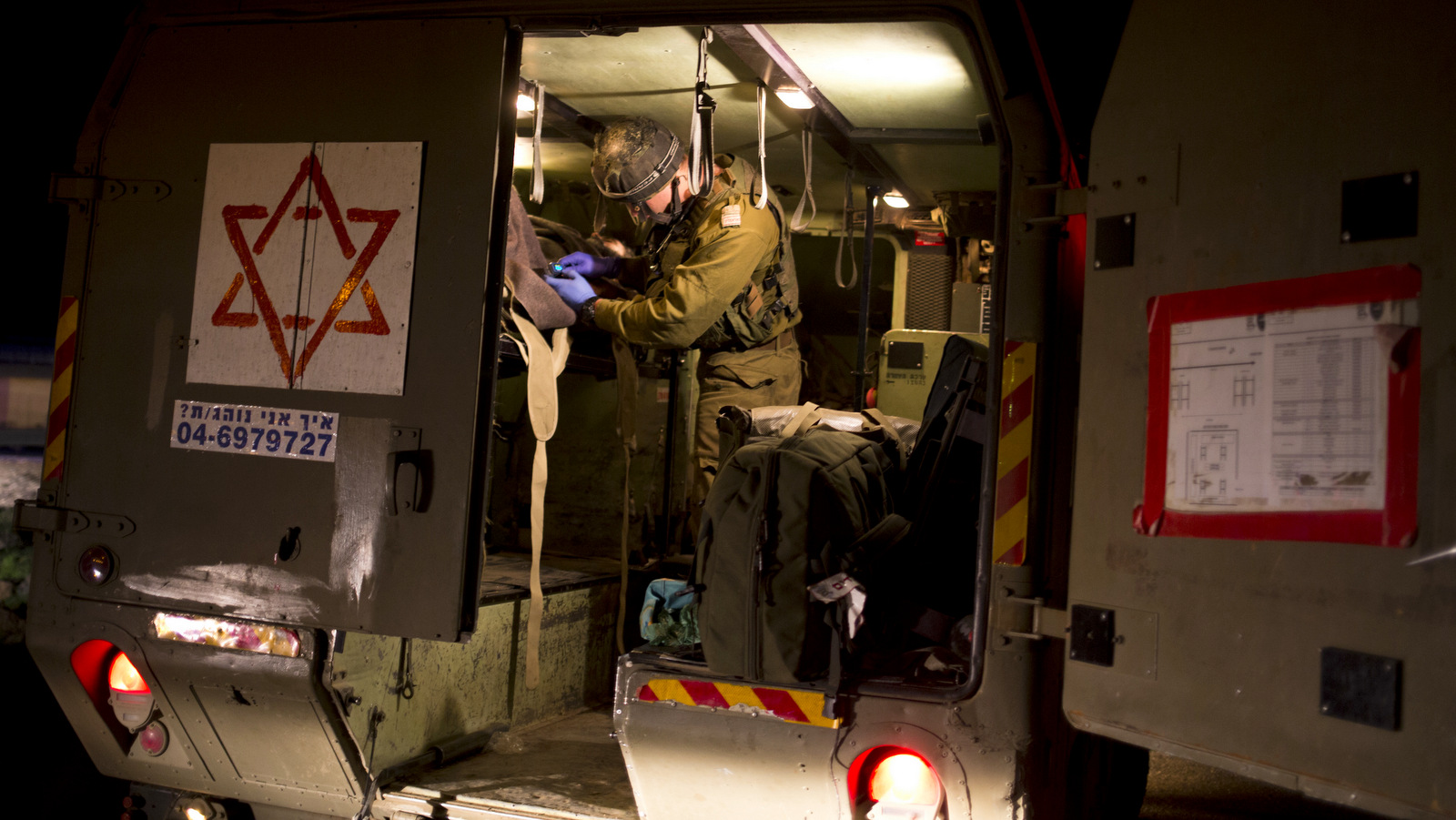 In this Thursday, April 6, 2017 photo made in Israeli controlled Golan Heights, Israeli military medics assist wounded Syrians. Seven wounded Syrians crossed into Israeli controlled Heights Thursday night have received immediate treatment and were hospitalized later on. They are the latest group of Syrian fighters receiving free medical care through an Israeli military program operating since 2013. (AP/Dusan Vranic)