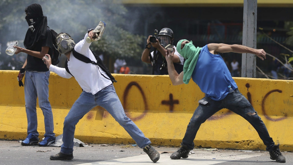 Demonstrators throw stones toward the Venezuelan National Guards during a protest in Caracas, Venezuela, Monday, April 10, 2017. (AP/Fernando Llano)