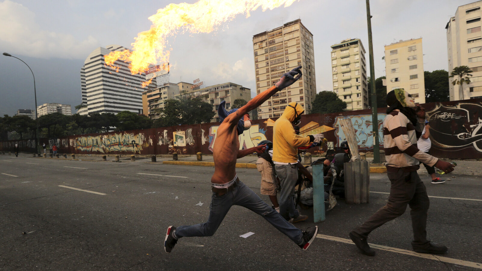 An anti-government protesters throws a molotov bomb at security forces in Caracas, Venezuela, Wednesday, April 19, 2017. Tens of thousands of opponents of President Nicolas Maduro flooded the streets of Caracas in what's been dubbed the "mother of all marches" against the embattled socialist president. (AP/Fernando Llano)