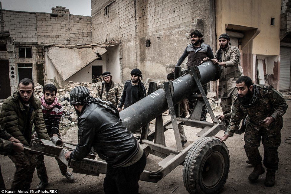 Member of the Free Syrian Army ready a homemade weapon known as a 'hell cannon' in the ruins of the city of Aleppo.