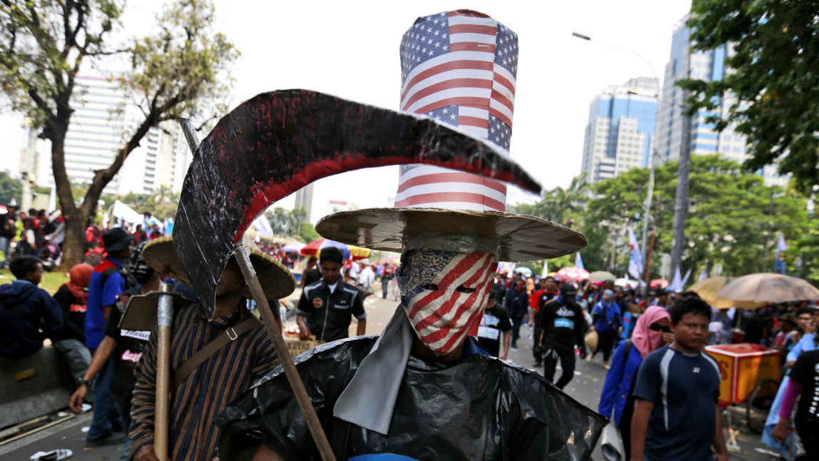 A worker is dressed in a costume representing the world's capitalism during a May Day rally in Jakarta, Indonesia, May 1, 2017. Thousands of workers attended the rally urging the government to raise minimum wages, ban outsourcing practices, provide free health care and improve working condition for workers in the country. Dita Alangkara | AP