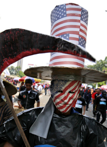 A worker is dressed in a costume representing the world's capitalism during a May Day rally in Jakarta, Indonesia, May 1, 2017. Thousands of workers attended the rally urging the government to raise minimum wages, ban outsourcing practices, provide free health care and improve working condition for workers in the country. Dita Alangkara | AP