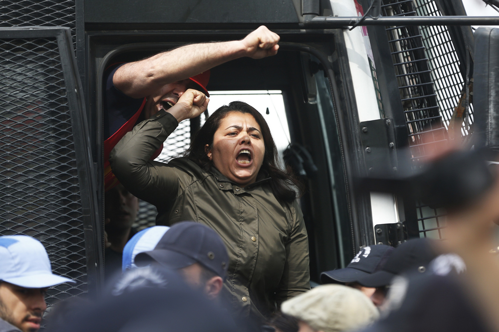 Detained protesters chant a slogan from inside a police in Istanbul, Monday, May 1, 2017. Police in Istanbul detained more than 70 people who tried to march to iconic Taksim Square in defiance of a ban on holding May Day events there. Workers and activists marked May Day with defiant rallies and marches for better pay and working conditions Monday.
